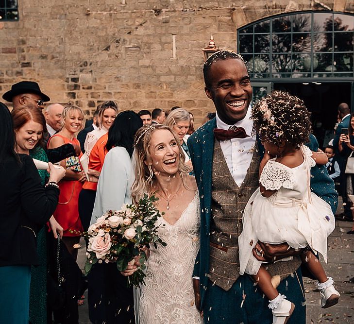 Bride, groom and daughter confetti moment by Abbie Sizer Photography