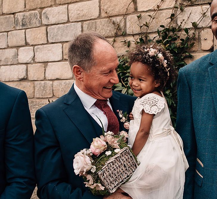 Grandfather holding his flower girl granddaughter