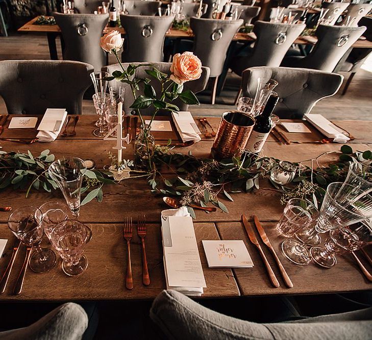 Wedding table decor with copper cutlery and foliage table runners