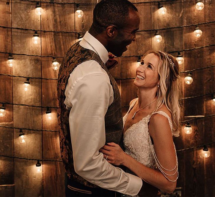 Bride and groom portrait with festoon light backdrop