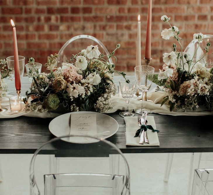 Elegant wedding table decor with ghost chairs, flower centrepieces and taper candles