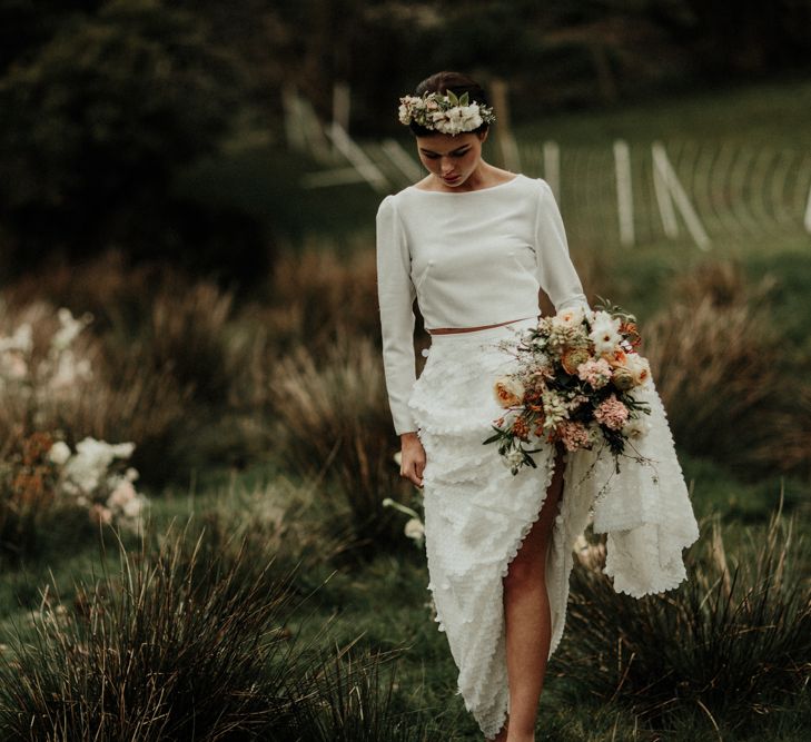 Boho bride in flower down sequin skirt and bridal crop top walking in the Welsh countryside