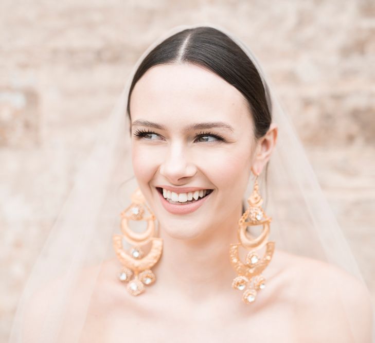 Smiling Bride with Natural Makeup &amp; Sleek Wedding Hair Showing off Statement Earring