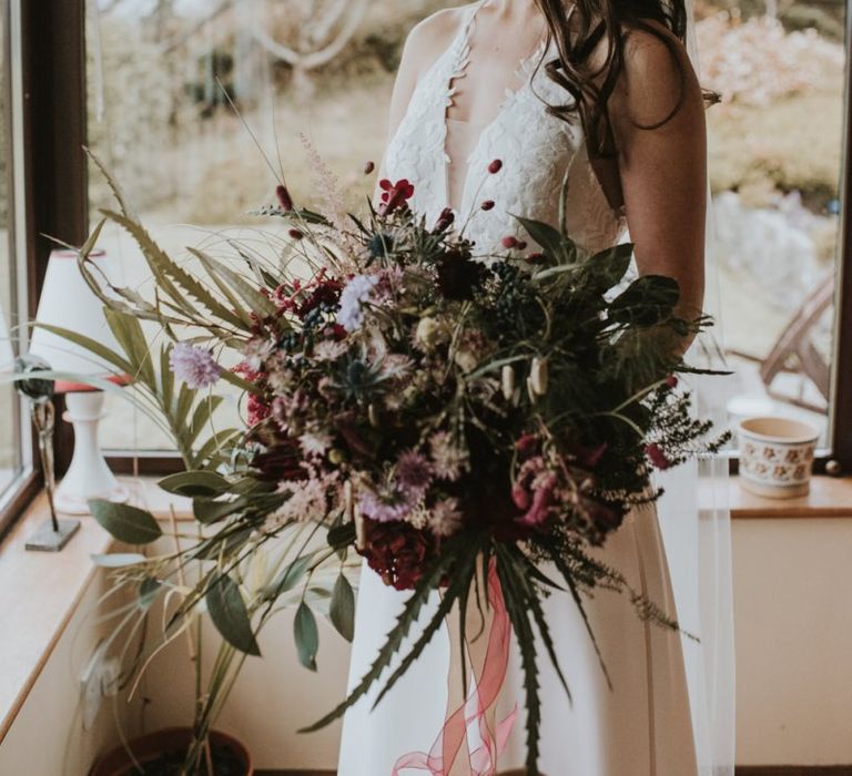 Beautiful Bride Holding an Oversized Deep Red and Green Dried Flower Bouquet