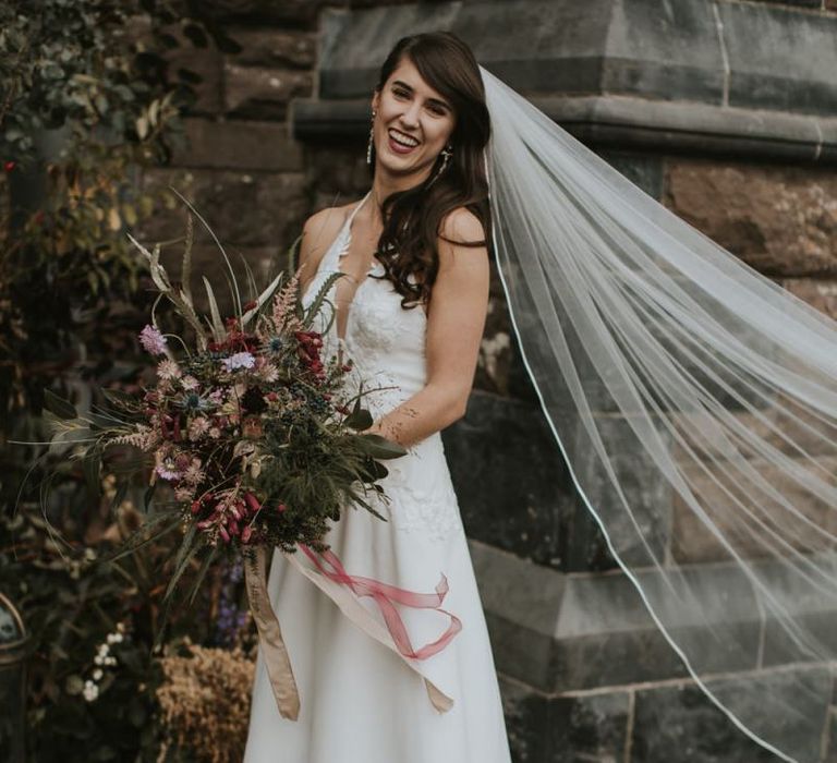 Beautiful Bride in High Low Elbeth Gillis Wedding Dress and Veil Holding an Oversized Autumn Bouquet