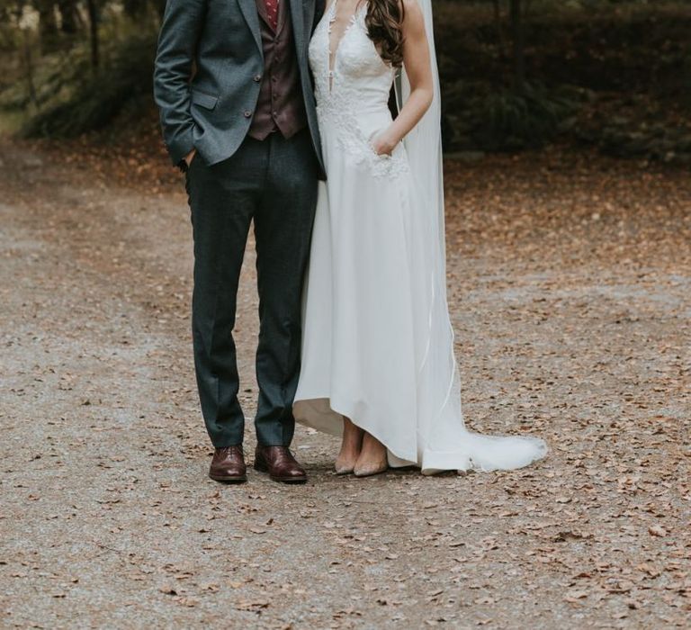 Bride in Elbeth Gillis Wedding Dress and Groom in  Tweed Suit  Arm in Arm