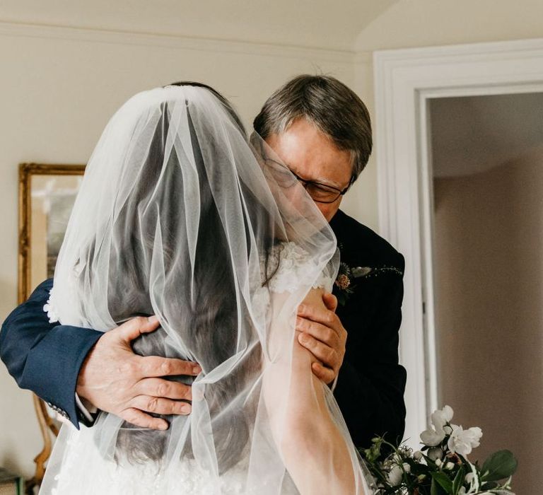 Father of the bride hugging his daughter on the wedding morning