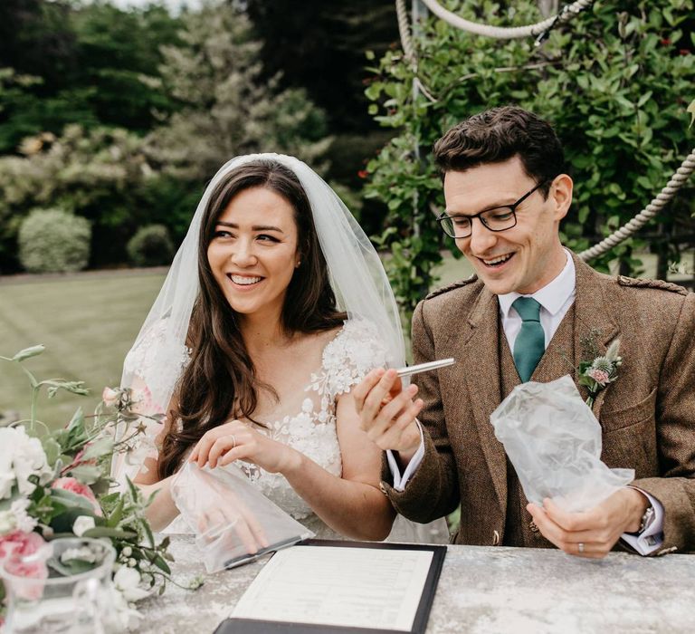 Bride and groom signing the register at post COVD wedding