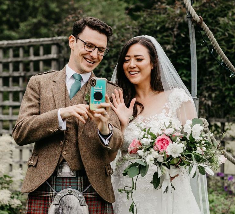 Bride and groom video calling wedding guests after their intimate post COVD wedding ceremony