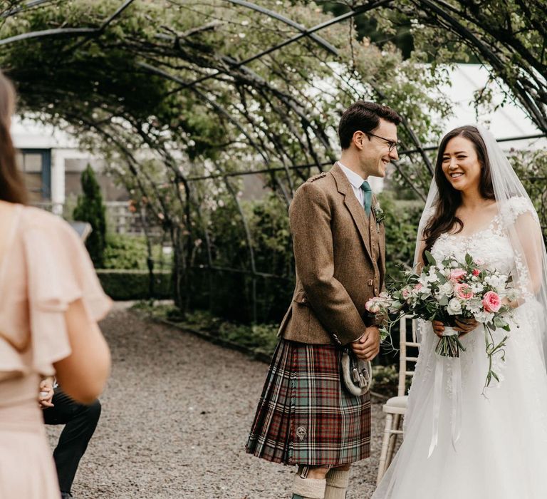 Bride in lace and tulle wedding dress and Groom in Tartan kilt at socially distanced wedding