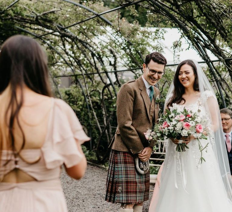 Bride and groom smiling at outdoor wedding ceremony