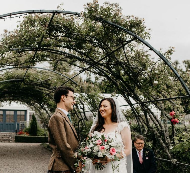 Groom in tartan kilt and bride in romantic wedding dress