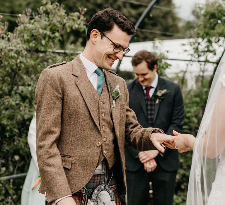 Bride and groom exchanging wedding rings at socially distanced wedding