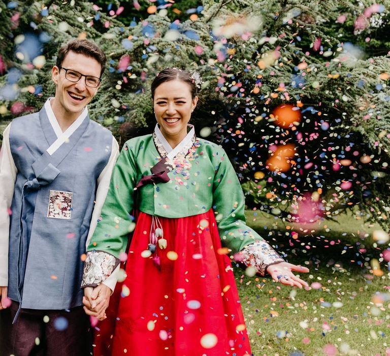 Confetti moment at multicultural wedding with tailor made Hanboks Korean wedding dress outfits