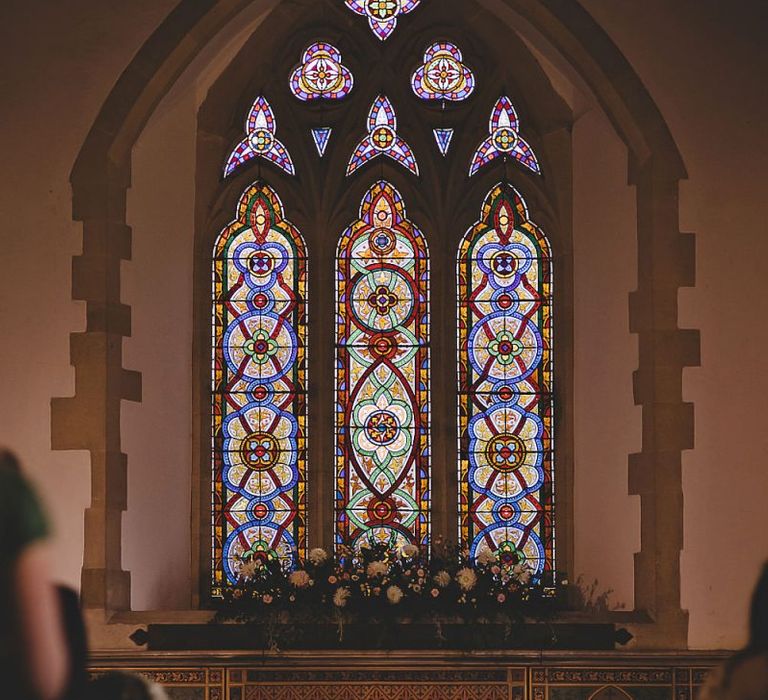 Bride and groom say 'I Do' at church ceremony  with home-grown floral decor