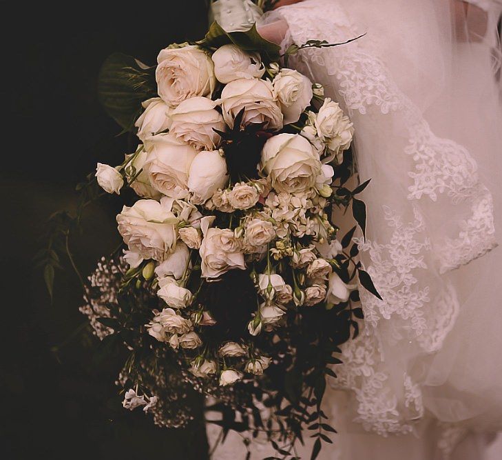 Brides beautiful white rose bouquet and long statement veil