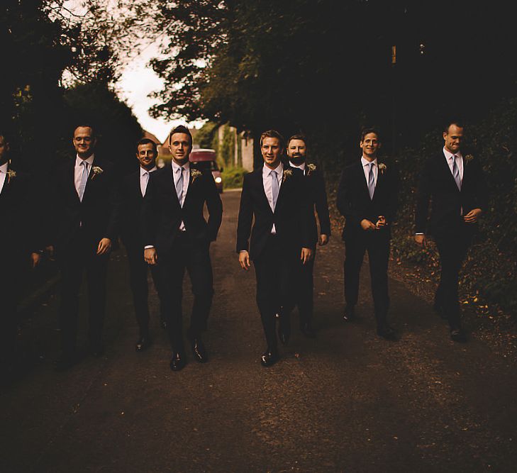 Groom and his ushers walking to the church through the village