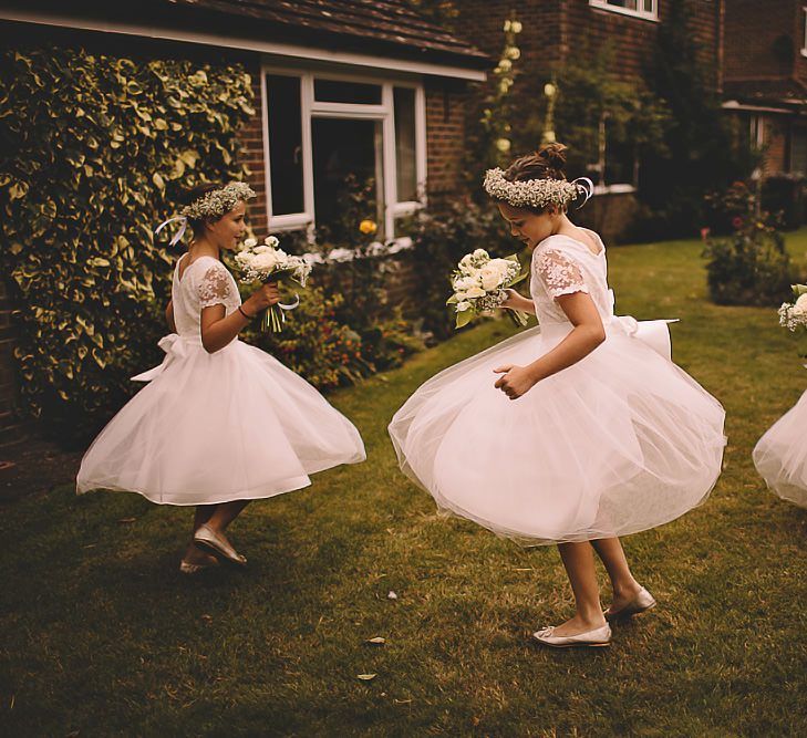 Flower girls wearing gypsophila flower crowns and pretty dresses with tulle skirts