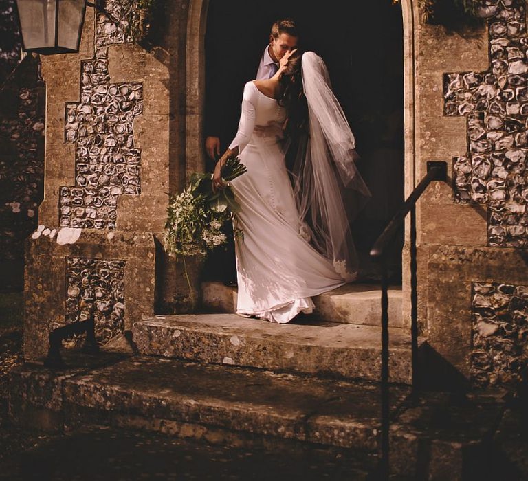 Bride wearing classic dress and statement veil with white rose bouquet