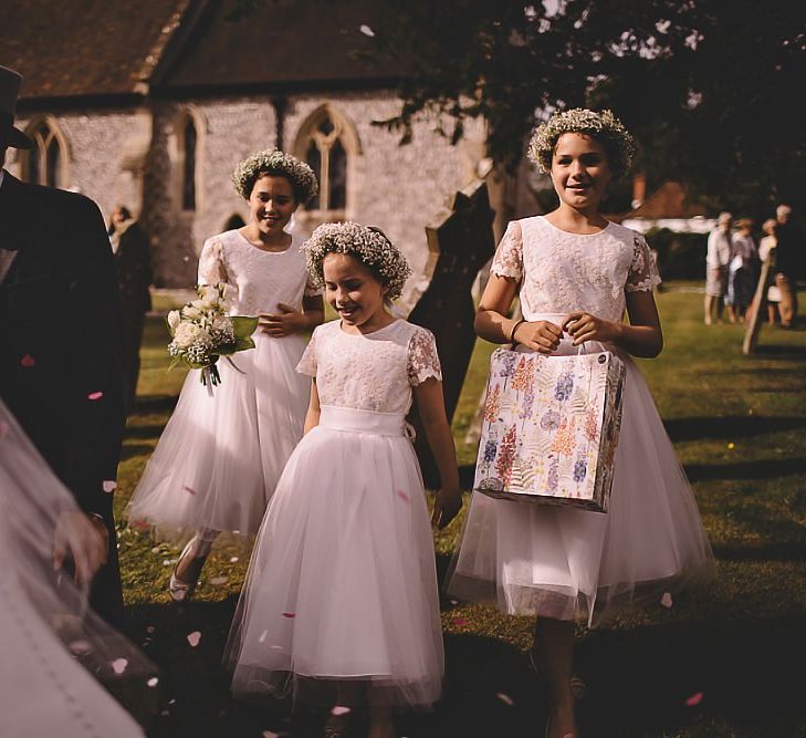 Flower girls wearing gypsophila flower crowns and pretty dresses with tulle skirts