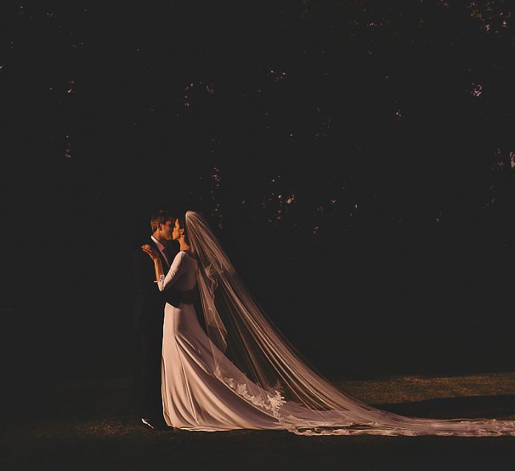 Bride wearing simple dress and extraordinary veil for sunset wedding shot