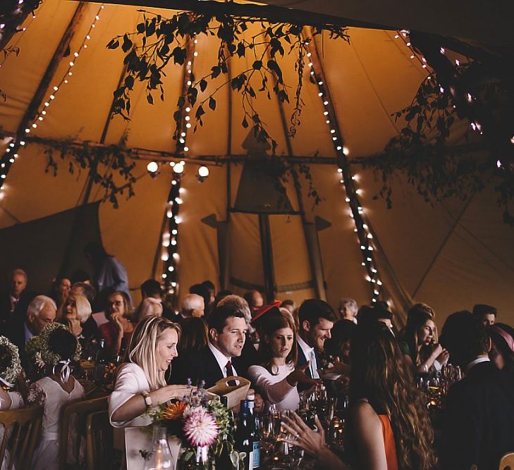 Tipi reception styled with wild meadow flowers and fairy lights