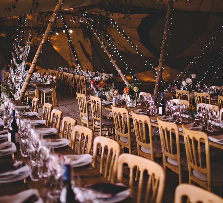 Garden party tipi reception in August with home-grown floral table arrangements and fairy lights