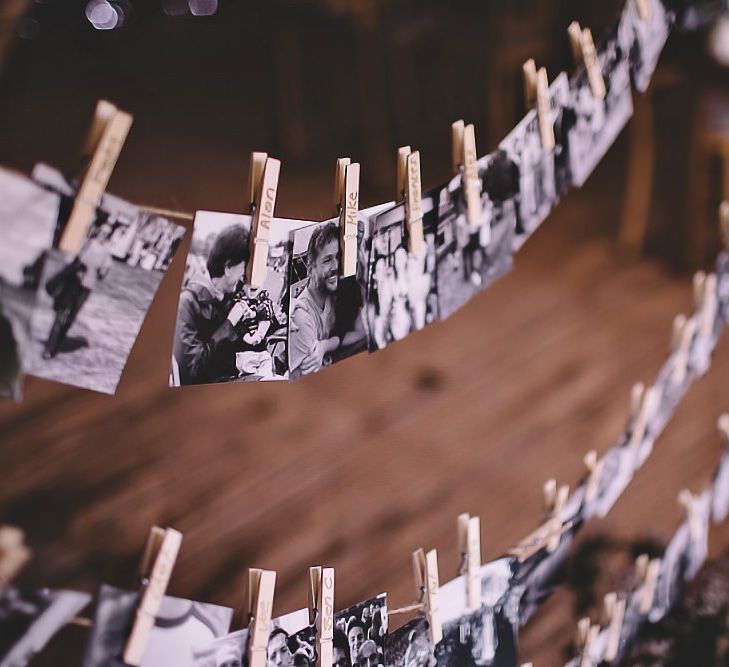 Black and white polaroid images hung with pegs at tipi garden party reception