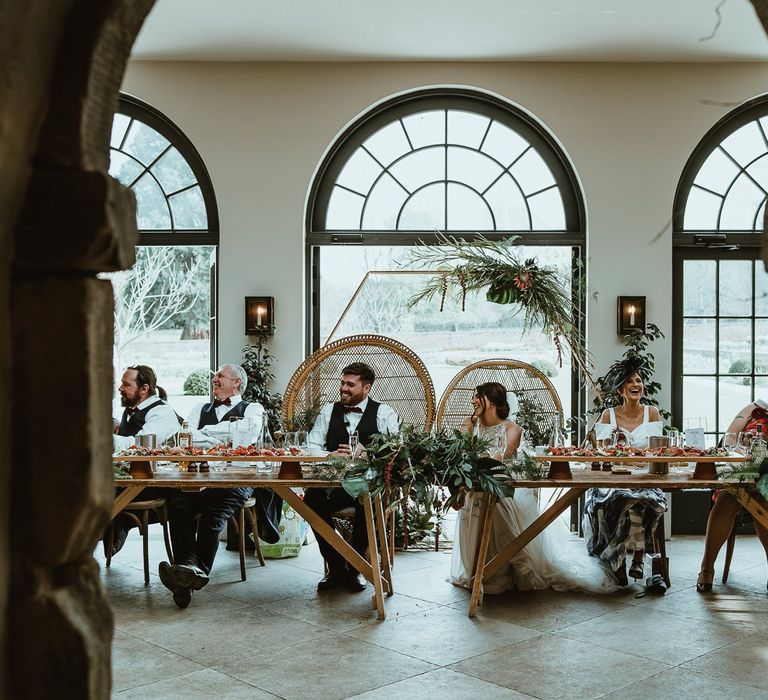 Bride and Groom Sitting on Peacock Chairs