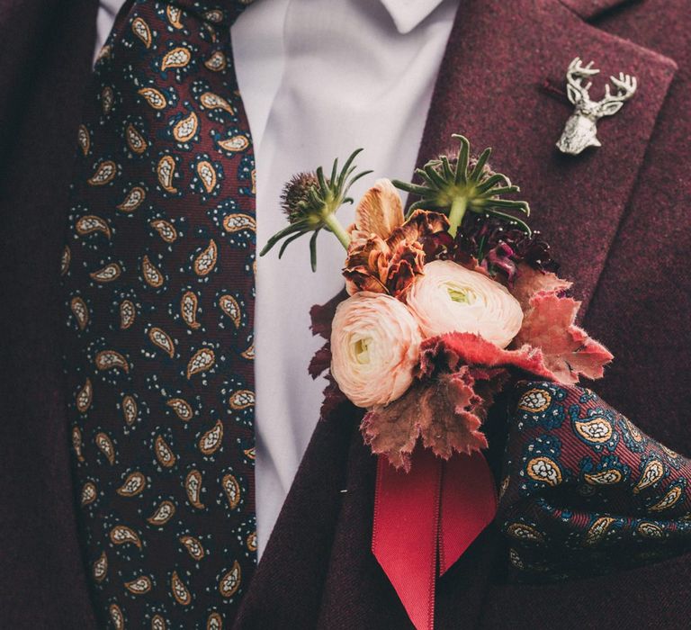 Groom in Burgundy Wool Suit with Deep Floral Buttonhole