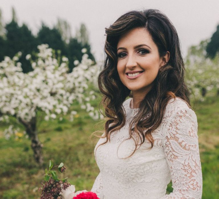 Beautiful Bride in Lace Wedding Dress Holding a Vibrant Burgundy, Red and Pink Wedding Bouquet