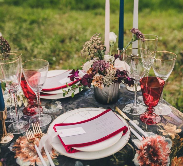 Elegant Place Setting with Gold Rimmed Glasses, Red Napkin and Menu Card