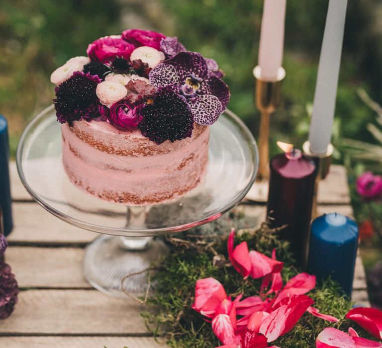 Single Tier Pink Wedding Cake on Glass Cake Stand Decorated with Wedding Flowers