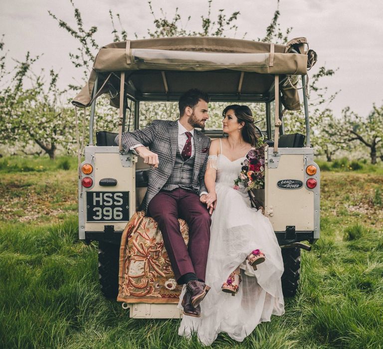 Bride and Groom Sitting on the Back of Land Rover