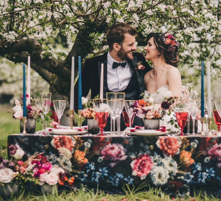 Bride and Groom Sitting at Their Outdoor Wedding Breakfast Table