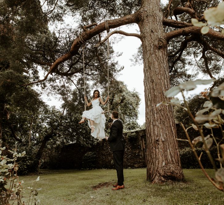 Bride swinging on a trapeze in homemade wedding dress