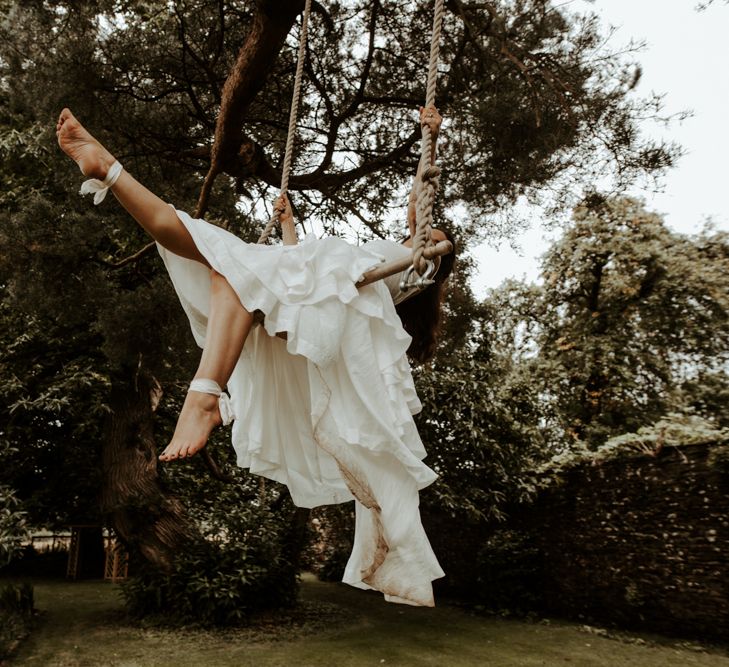 Bride swinging on a trapeze in layered skirt wedding dress