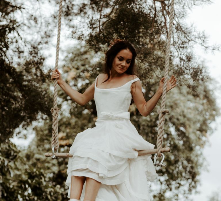 Bride swinging on a trapeze in high low wedding dress