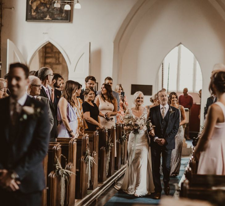 Bride walks down the aisle at church ceremony