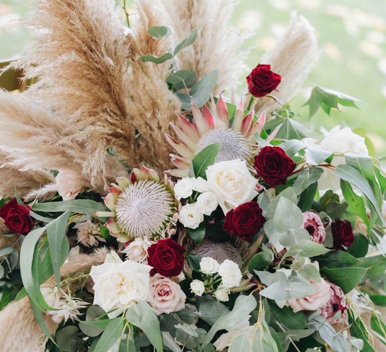 Red, Pink &amp; White Roses with Proteas &amp; Pampas Grass Floral Arrangement | Glamorous, Roaring Twenties, Great Gatsby Inspired Wedding at Villa Borromeo  in Italy | Matrimoni all’Italiana Photography