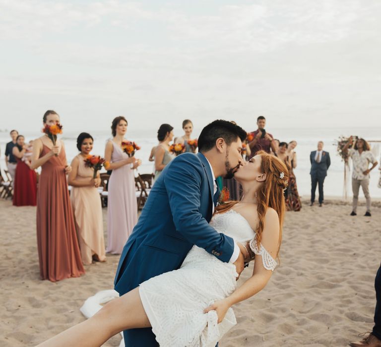 Groom Kisses Bride on Beach After Ceremony