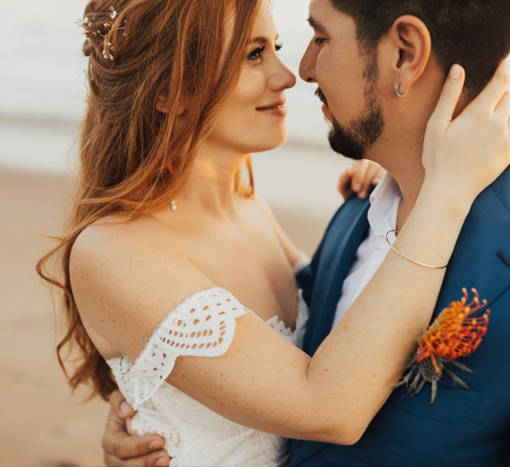 Bride and Groom in Navy Suit with Orange Floral Buttonhole