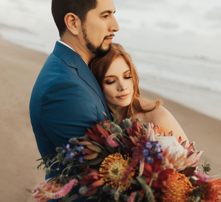 Bride and Groom Embrace With Bright Wedding Flowers