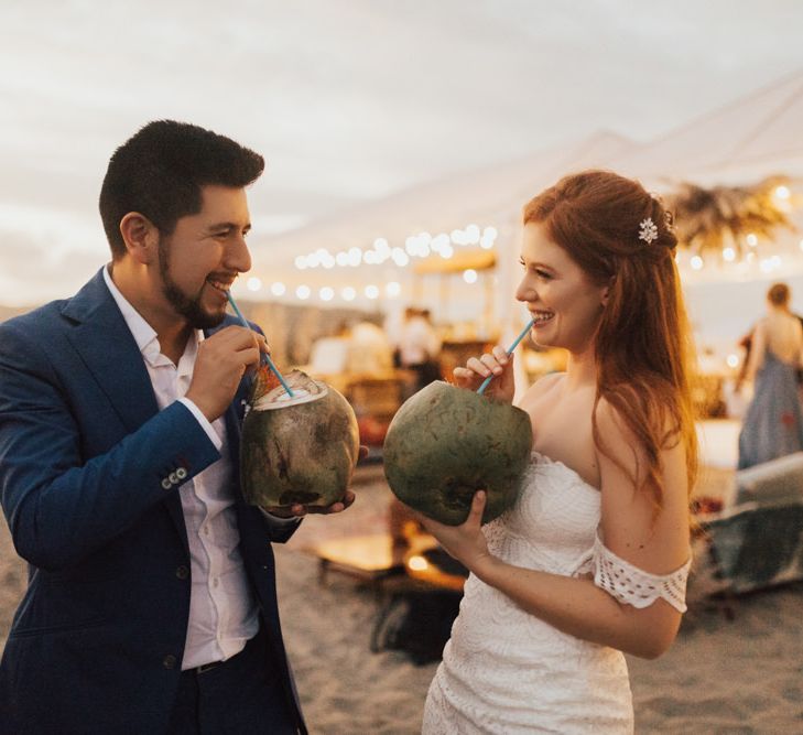 Bride and Groom Drink From Coconuts on Beach