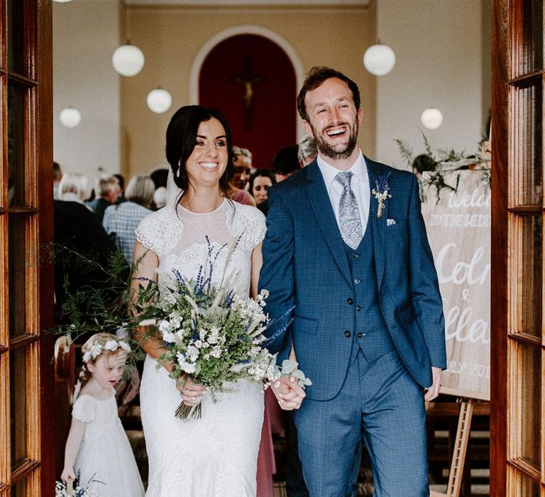 Bride in Jesus Peiro wedding dress with cap sleeves and wild flower bouquet