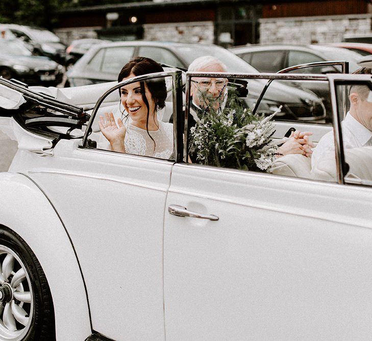 Bride arrives to wedding ceremony in Jesus Peiro wedding dress and white vintage wedding car