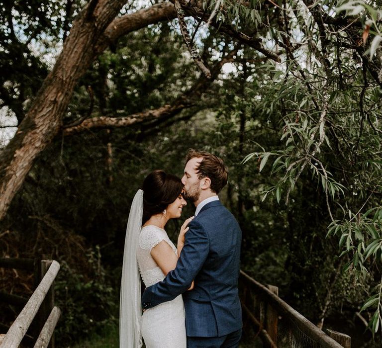 Bridal updo with mid-length veil and Jesus Peiro wedding dress