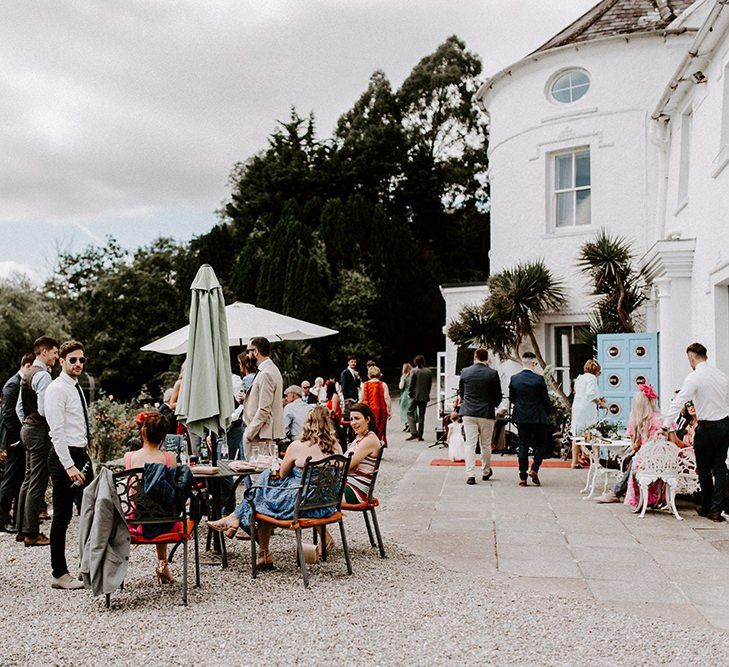 Guests enjoy drinks outside Innishannon House wedding venue