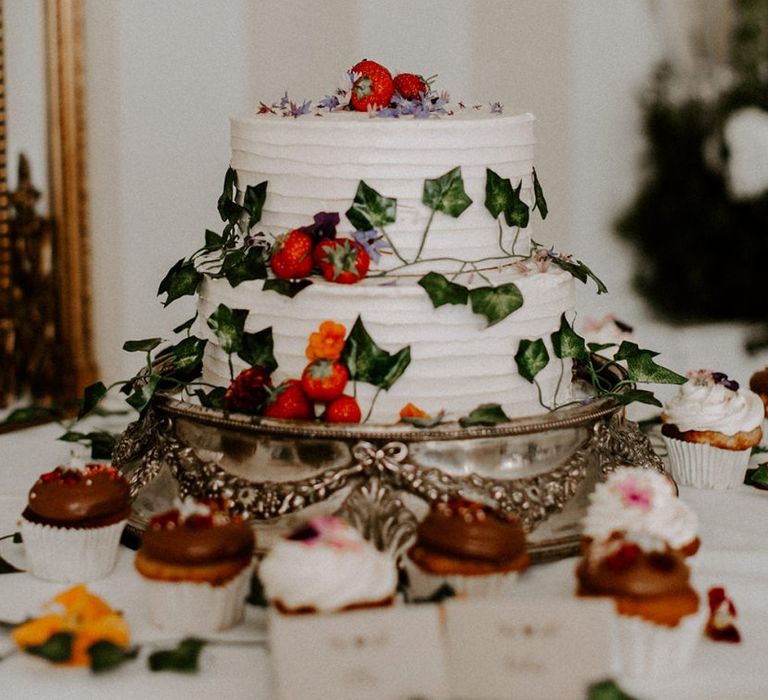 White wedding cake with foliage and berries