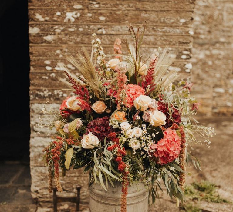 Rustic wedding flowers in milk churn